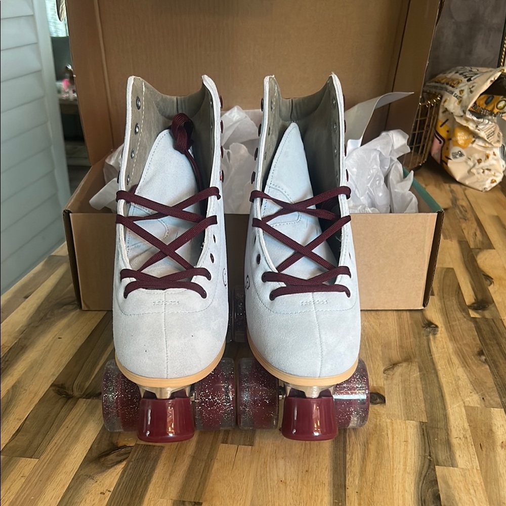 White and burgundy roller skates with glitter wheels.